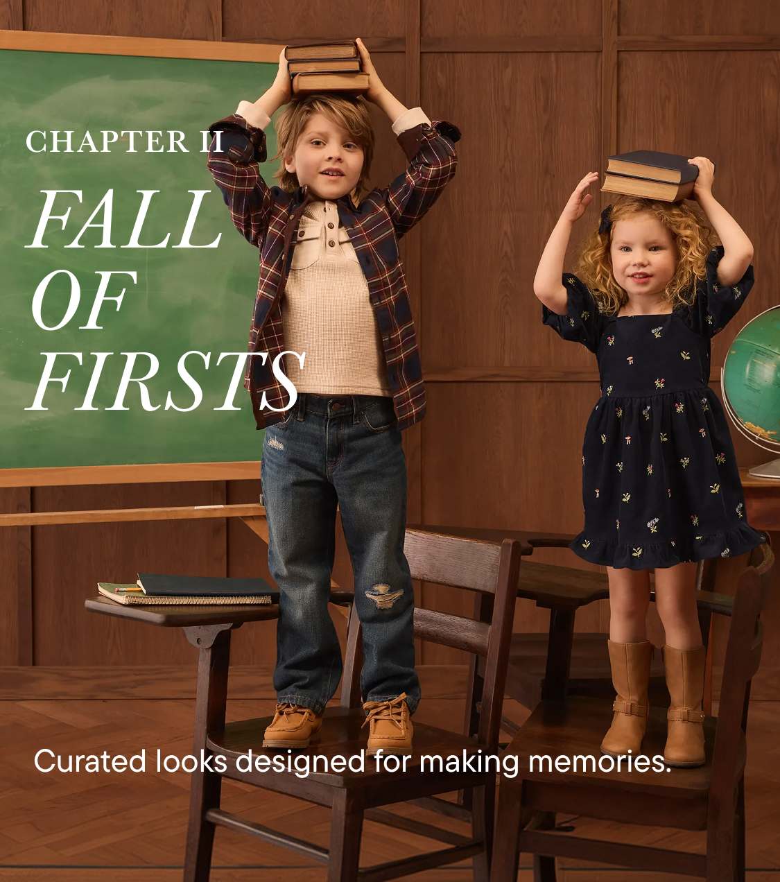 Two children balance books on their heads in front of a chalkboard and a globe in a classroom setting.