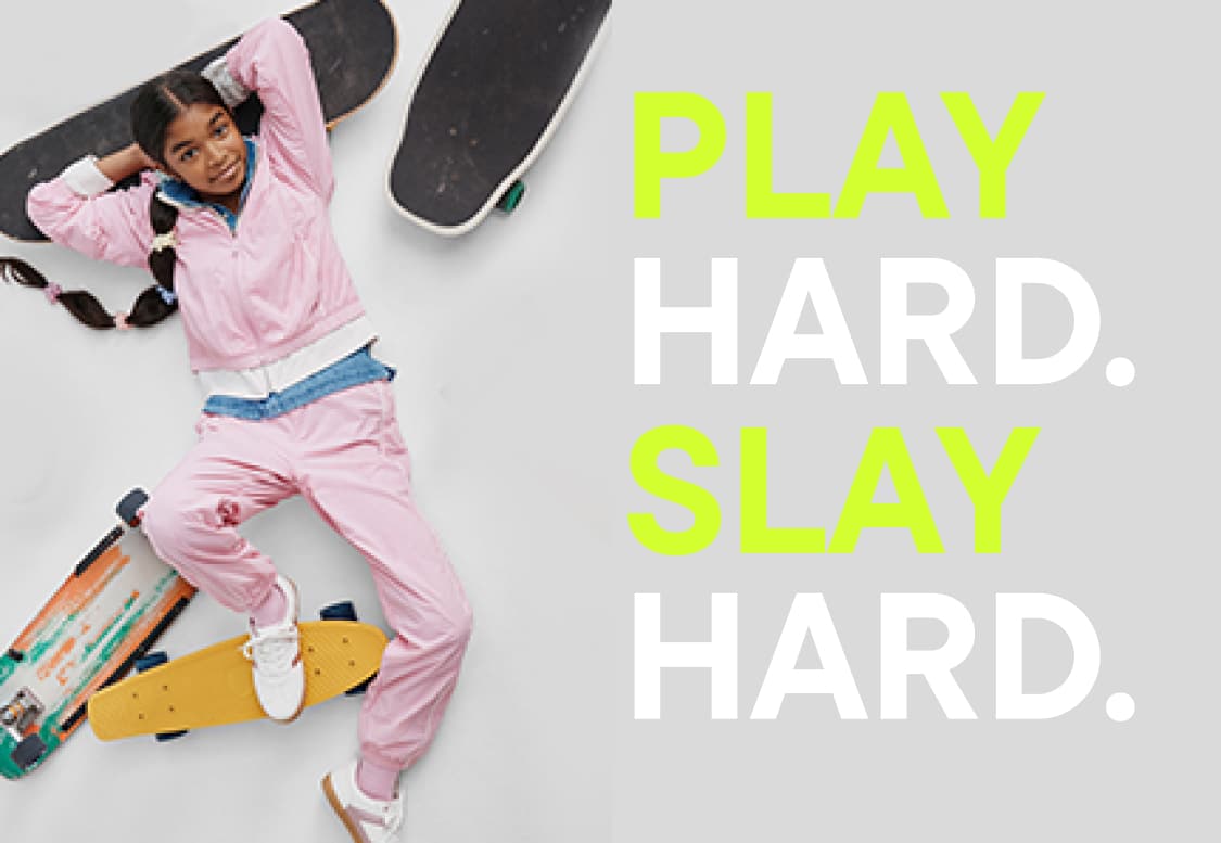 A person in a pink outfit is striking a dynamic pose while holding a skateboard against a white background with the text "SLAY" prominently displayed.