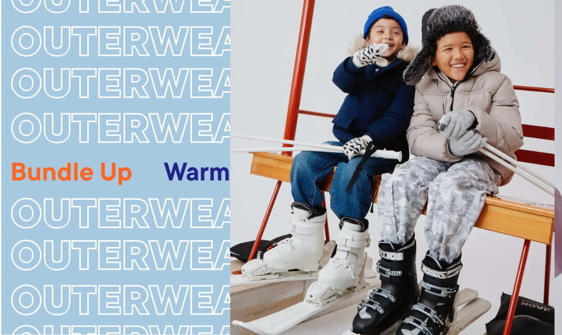 The image shows two people wearing warm winter outerwear, standing in front of a display of outerwear products with the text "Outerwear" prominently displayed.