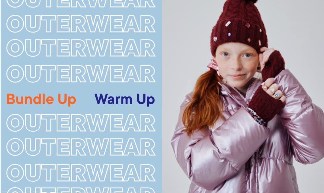 The image shows a young woman wearing a pink puffer jacket and jeans, standing on a skateboard in front of a background with the word "OUTERWEAR" repeated multiple times.