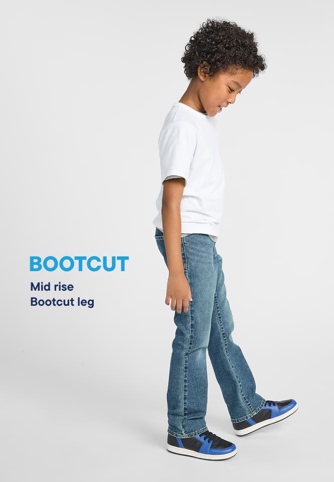A person wearing a navy blue tracksuit with white stripes stands in front of a large blue "Bootcut" logo.
