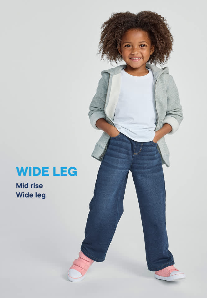 A young girl in wide-leg jeans and a hoodie stands against a plain background with text.