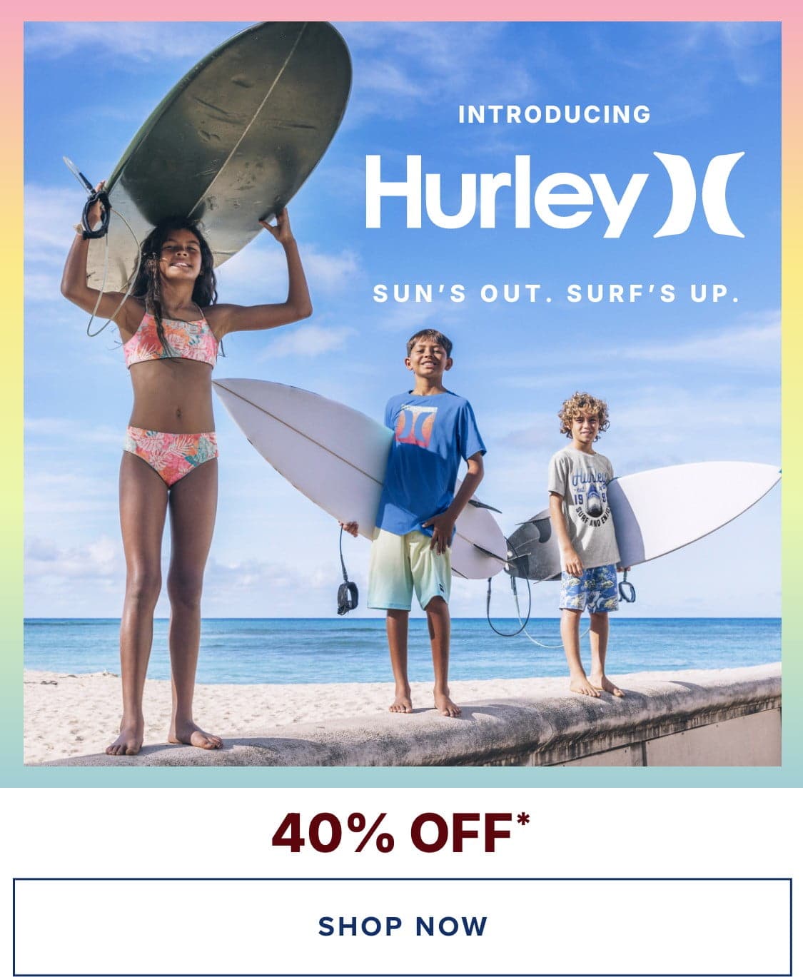 Three people, two children and one adult, standing on a beach holding surfboards and wearing Hurley-branded clothing. The background shows a clear blue sky and ocean, creating a vibrant and summery scene.