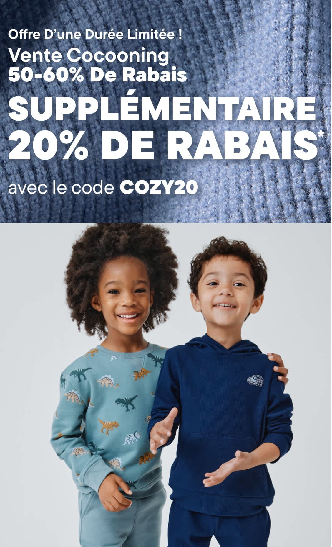 L'image représente deux jeunes enfants, un garçon et une fille, debout l'un contre l'autre et souriant. Le fond est une surface grise texturée, et l'image fait la promotion d'une « Vente Cozy » avec une réduction de 50 à 60 % et 20 % supplémentaires avec le code « COZY20 ».
