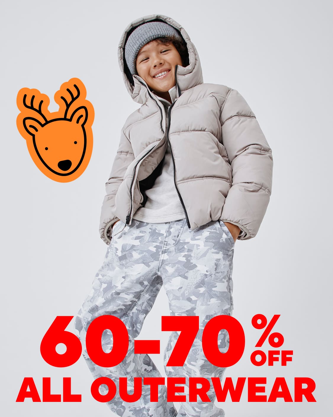 Una persona joven que viste una chaqueta acolchada con capucha gris y pantalones de camuflaje se encuentra frente a un fondo blanco, con un ícono grande en forma de ciervo naranja y una superposición de texto "60-70 % DE DESCUENTO EN TODAS LAS ROPAS DE ABRIGO".
