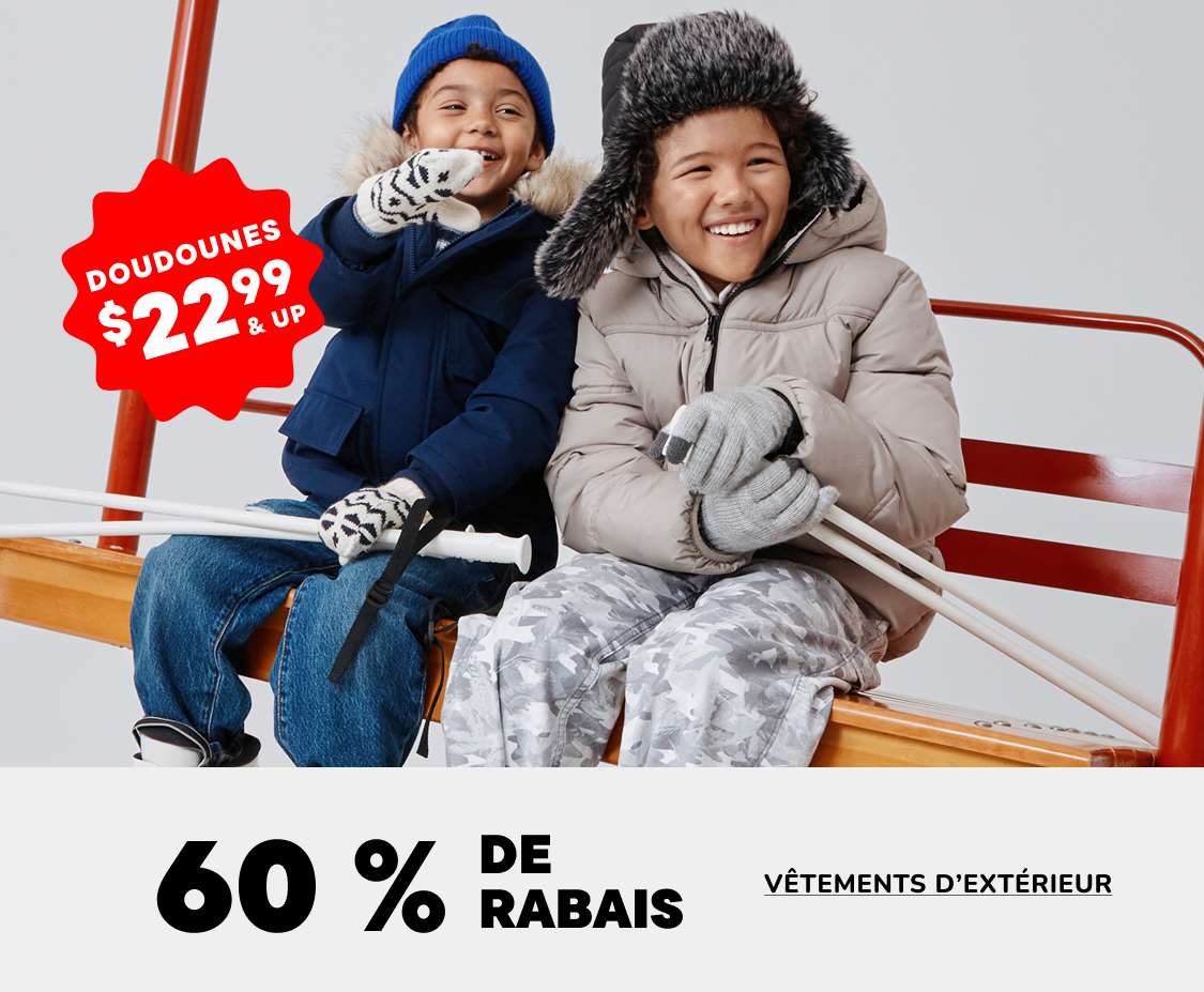 Deux jeunes gens, un garçon et une fille, sont assis sur un banc et sourient, vêtus de vêtements d'hiver. À l'arrière-plan, une affiche annonce une vente « Vendredi en solde » avec des réductions de 60 à 70 % sur les vêtements d'extérieur.
