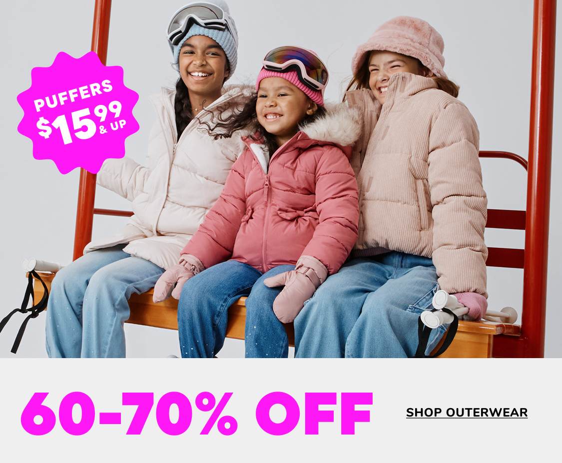 Two people, a young boy and girl, are sitting on a bench and smiling while wearing winter clothing. The background includes a sign advertising a "Friday Drop" sale with 60-70% off outerwear.
