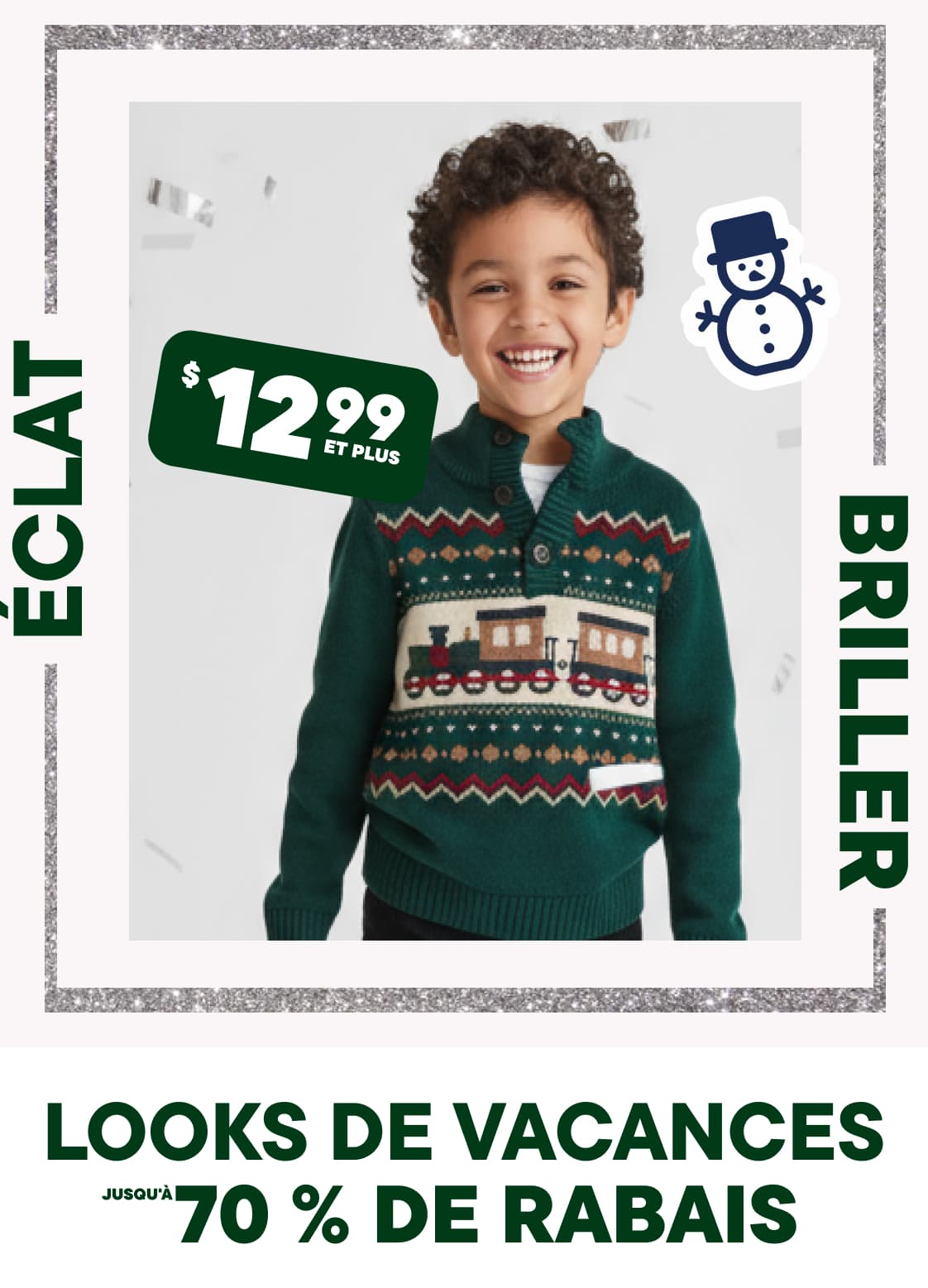 Un jeune garçon aux cheveux bouclés porte un pull à motifs verts et rouges et sourit à l'objectif, sur un fond orné d'une étiquette de prix et de motifs sur le thème des fêtes.