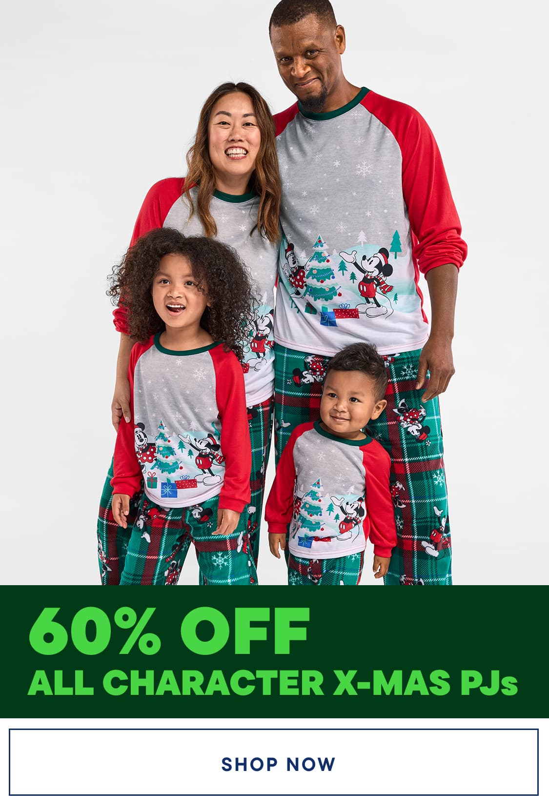 A happy family of four wearing matching Christmas-themed pajamas stands together, smiling brightly against a plain white background.