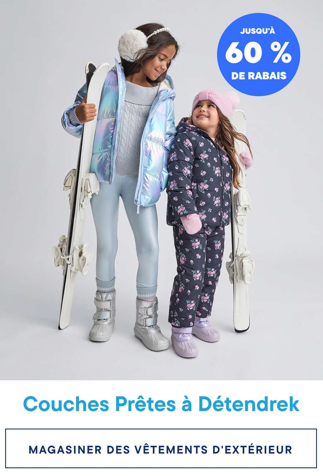 Two young girls wearing colorful winter outfits, including puffy jackets and snow pants, standing in front of a plain background with a promotional banner advertising "Chill-Ready Layers" and "Up to 70% Off" on graphic tees.