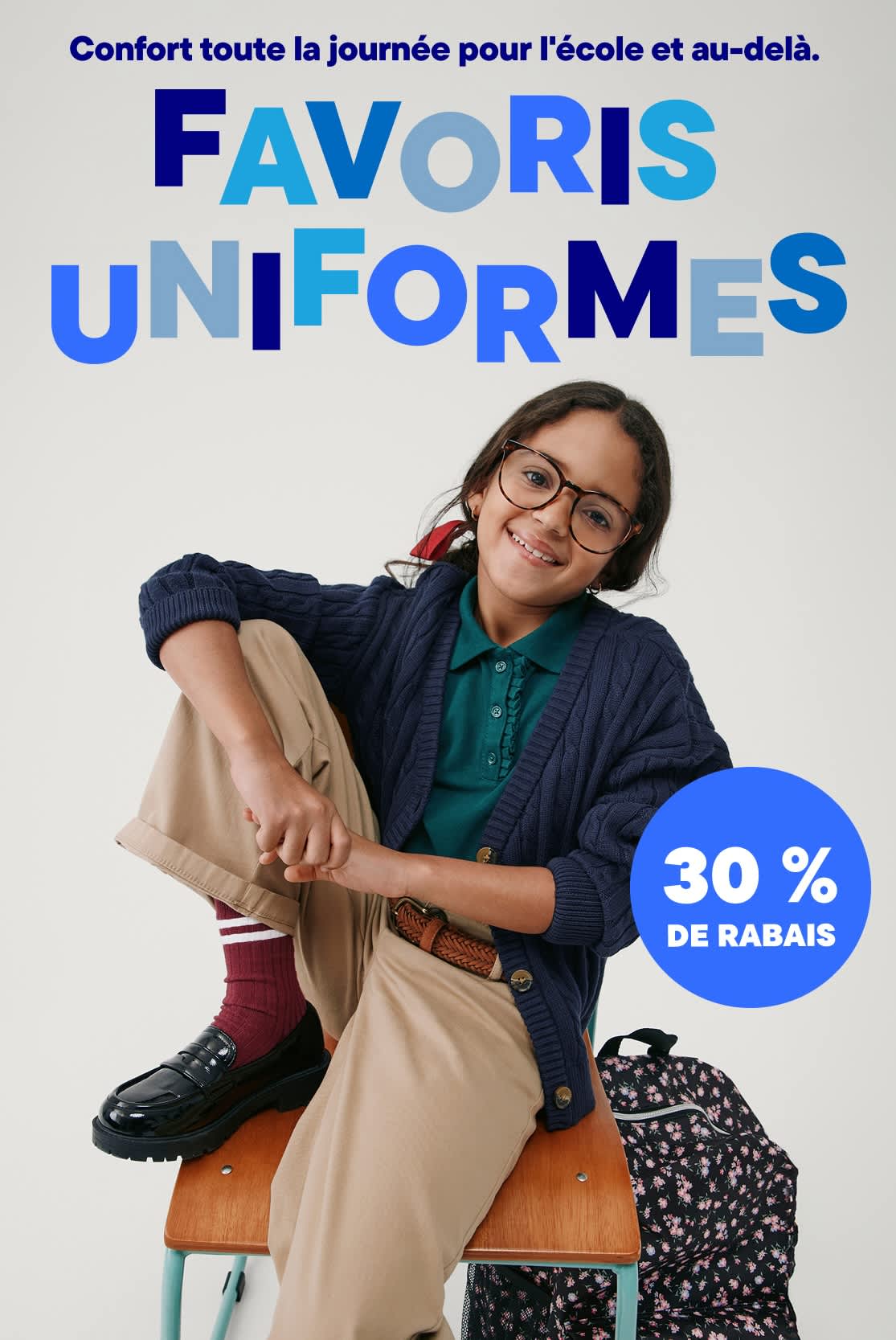 L'image montre deux jeunes gens, un garçon et une fille, vêtus de vêtements décontractés et posant devant une bannière publicitaire pour « Uniform Faves » offrant une réduction de 30 %.