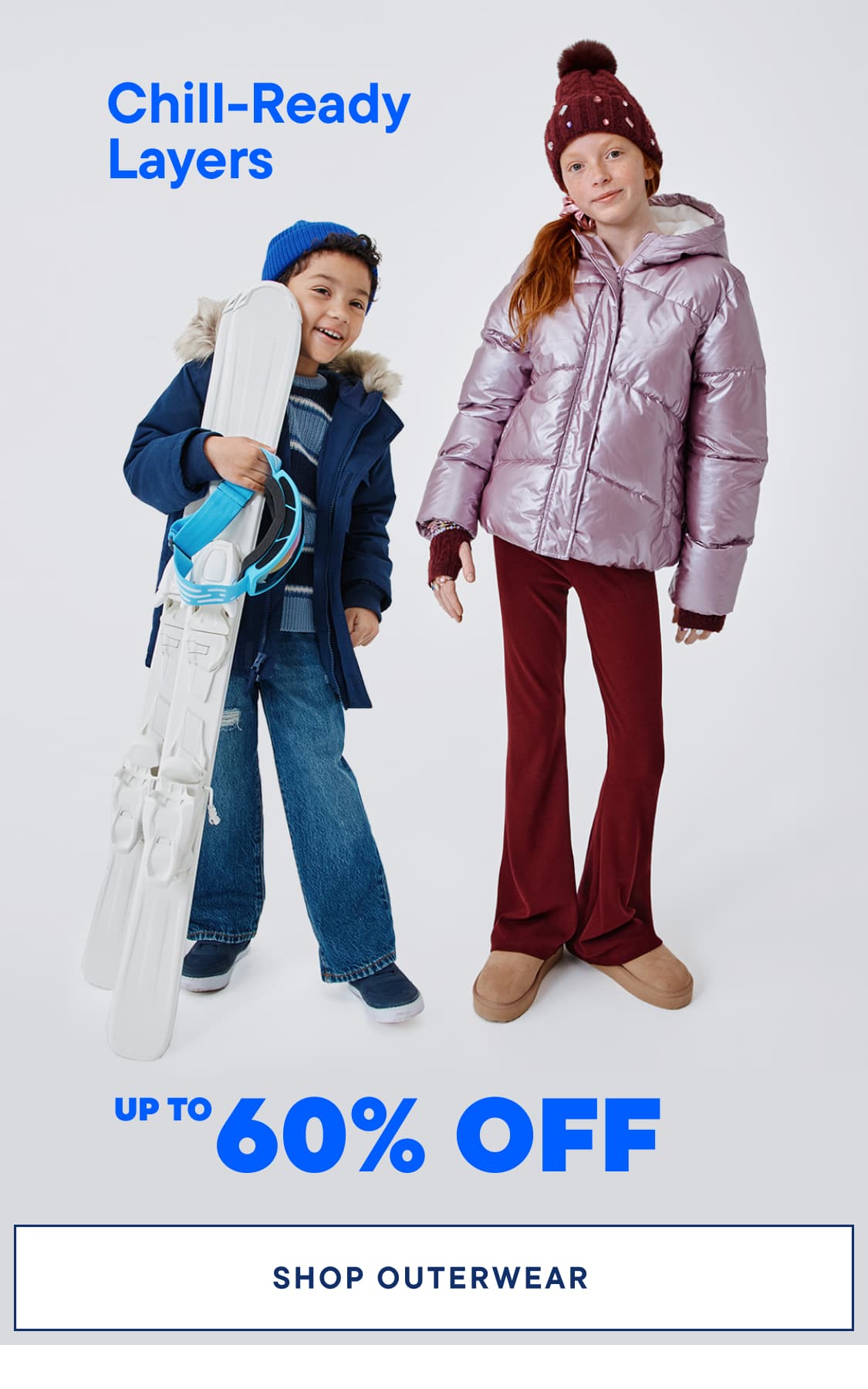 Two young children wearing winter outerwear, including a blue jacket and a pink puffy jacket, stand in front of a plain background with a promotional banner for outerwear discounts.