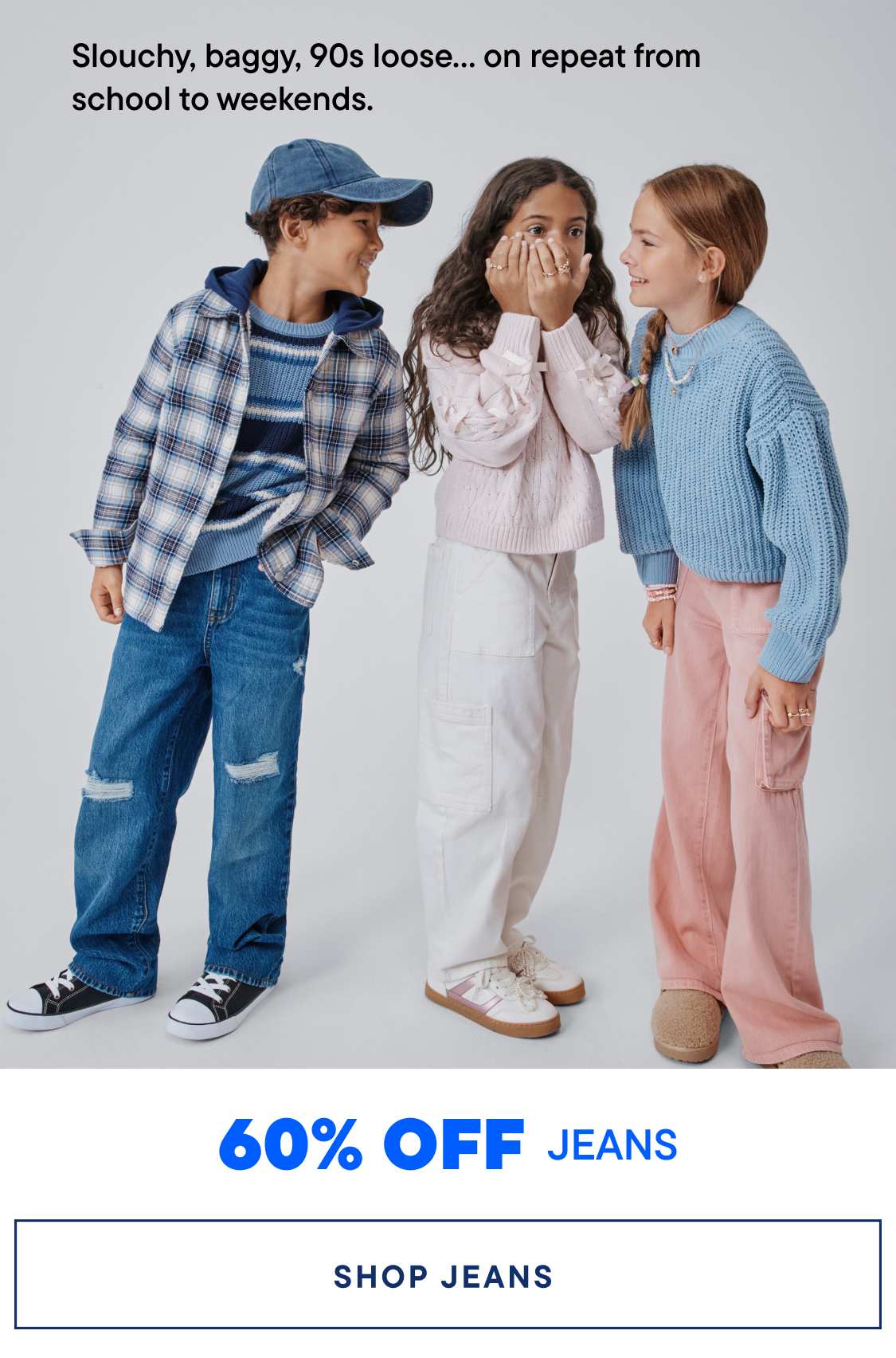 Three young children, a boy and two girls, are posing together in casual 90s-inspired outfits, with the text "Slouchy, baggy, 90s loose... on repeat from school to weekends." and "60% OFF JEANS" displayed in the background.