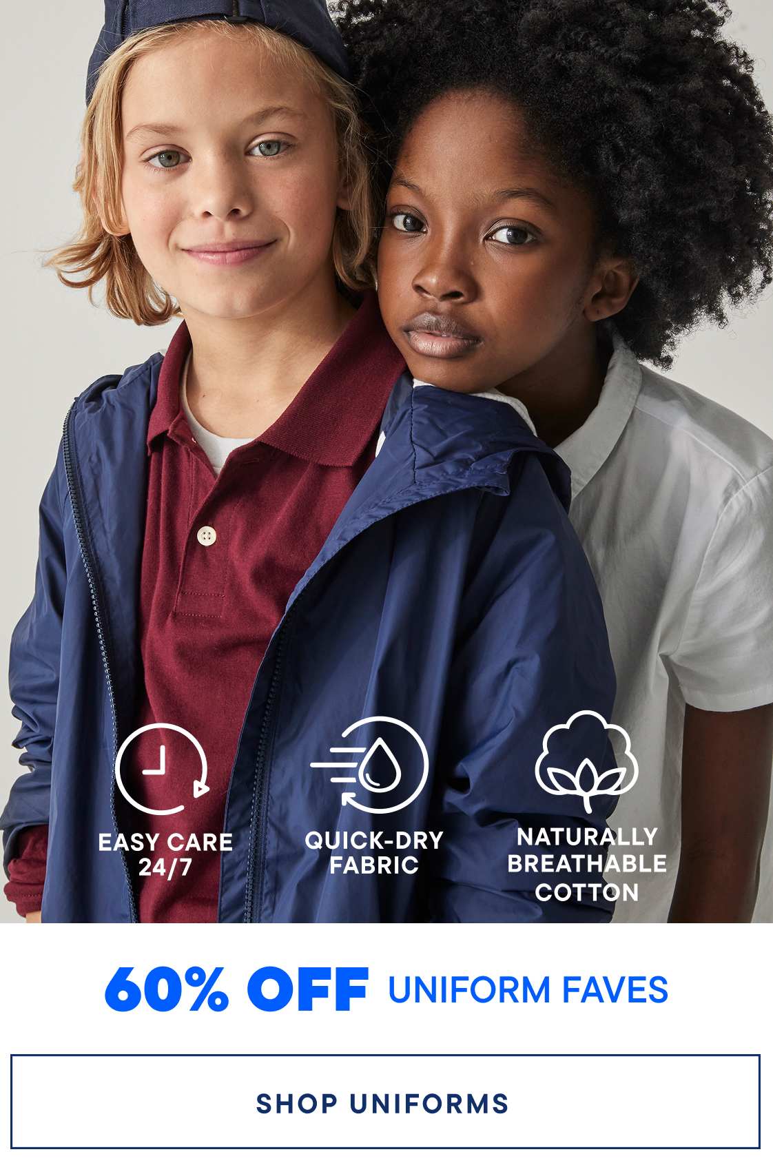 Two children, a boy and a girl, are standing together and wearing school uniforms. The background appears to be a plain white or light-colored surface, with text and graphics promoting the uniforms' features.