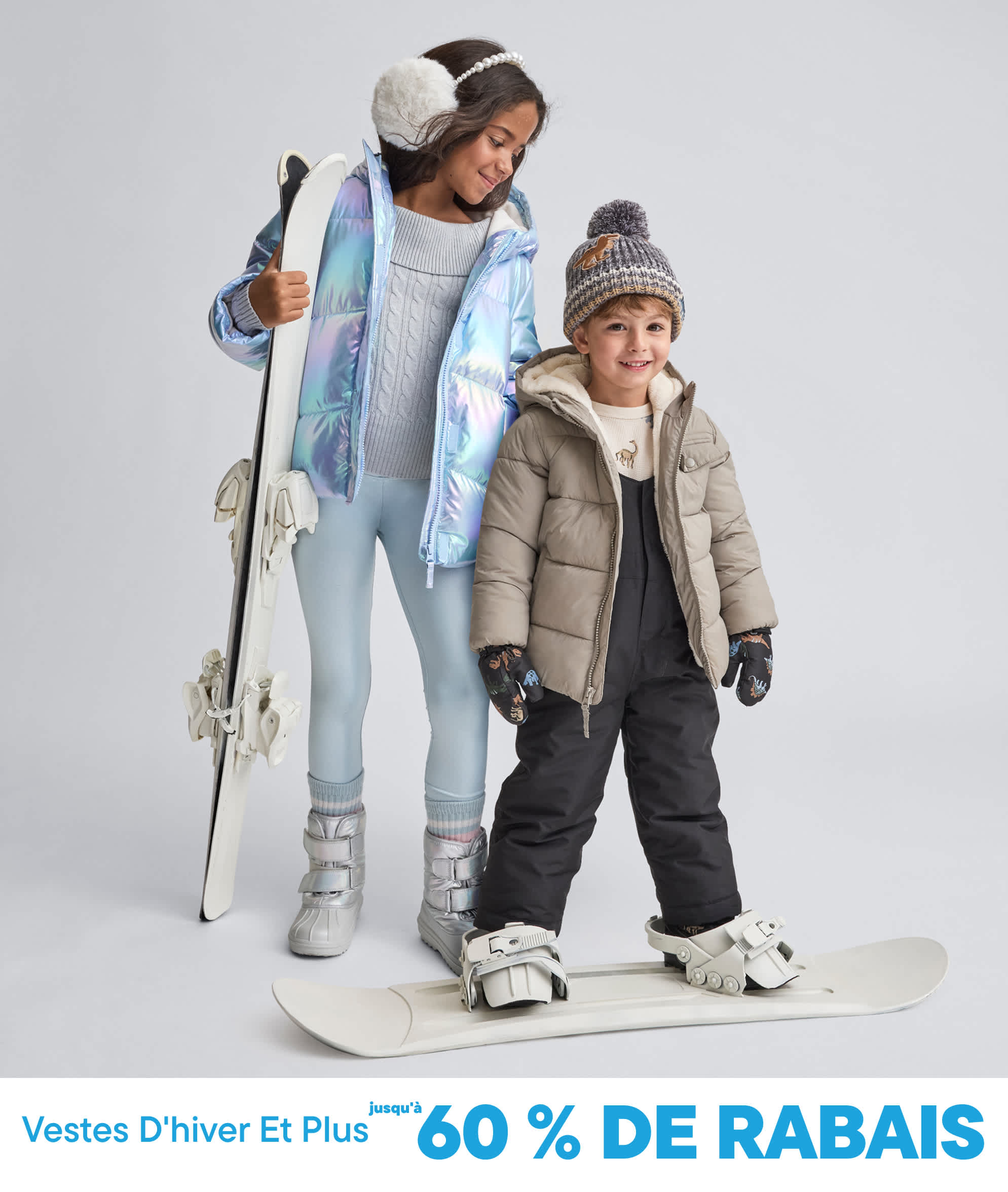 Deux jeunes gens, une fille et un garçon, vêtus de vêtements chauds d'hiver et tenant du matériel de ski, se détachent sur un fond blanc uni.