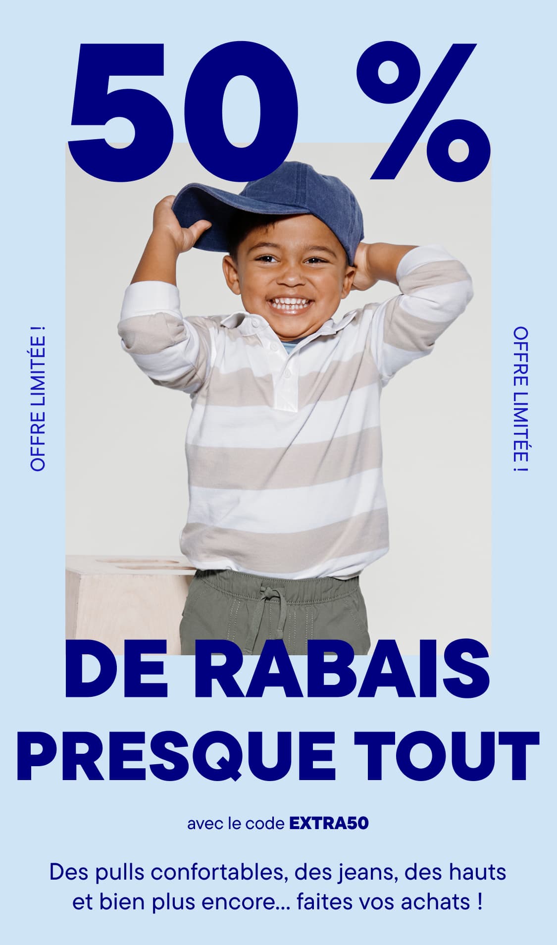 Un jeune garçon souriant, vêtu d'une chemise à rayures blanches et bleues et d'une casquette de baseball, se tient devant une grande affiche publicitaire annonçant « 50 % de réduction sur presque tout ».