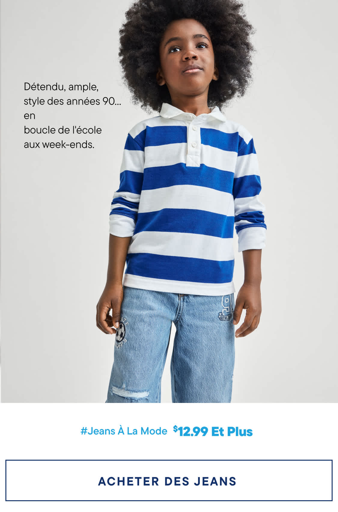 L'image montre un jeune enfant aux cheveux bouclés, vêtu d'un polo rayé bleu et blanc et d'un jean, sur fond blanc uni. Le texte en dessous annonce « Jeans tendance à partir de 12,99 $ » et invite le spectateur à « Acheter des jeans ».