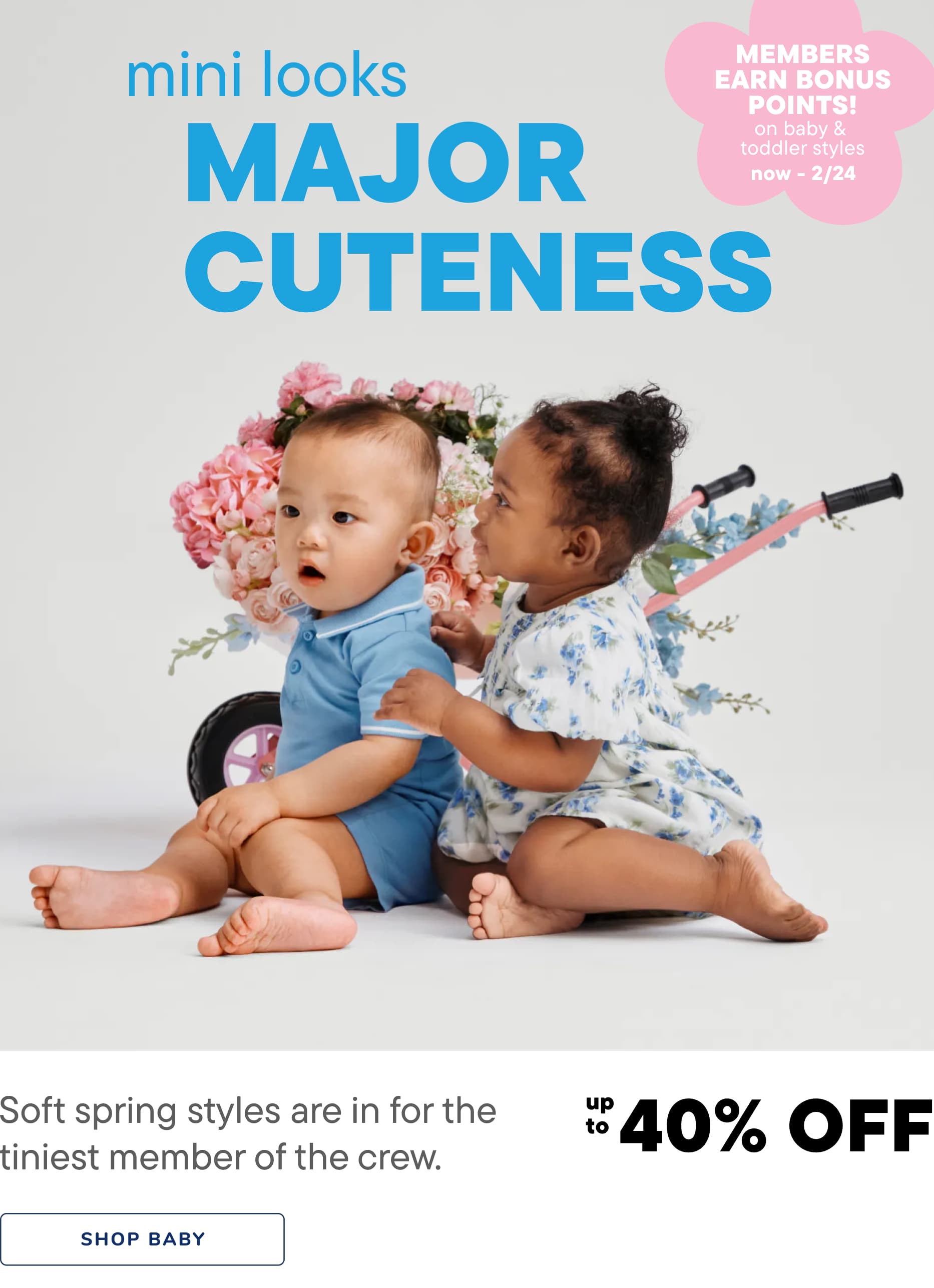 The image features two young children, a boy and a girl, sitting together on a floral background. The children are wearing colorful, spring-inspired outfits and appear to be engaging with each other in a playful and affectionate manner.