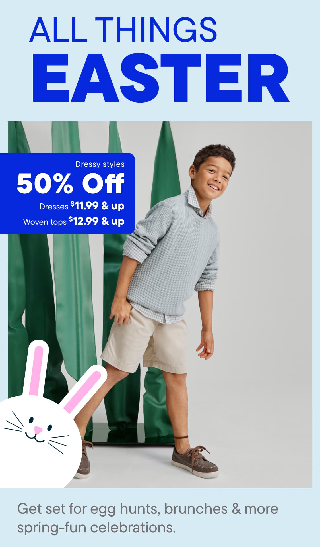 A young woman with curly blonde hair is smiling and holding a bouquet of flowers in front of a colorful floral background.