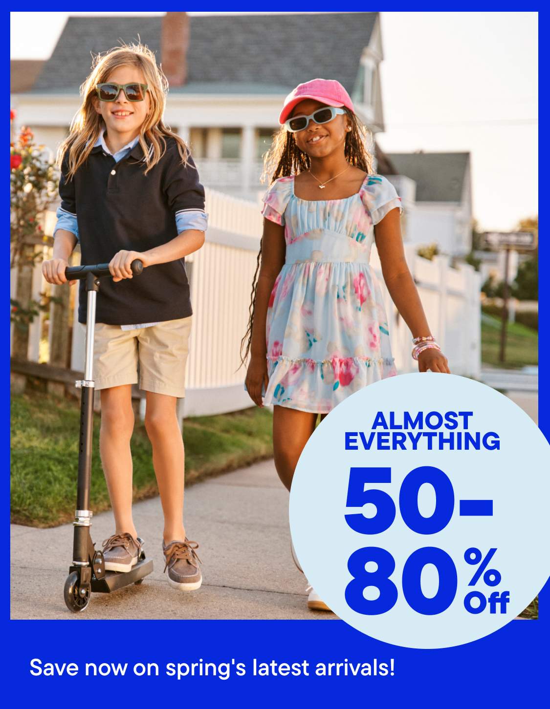 The image shows two young women standing in front of a large sign advertising a sale with discounts ranging from 50-80% off on almost everything.