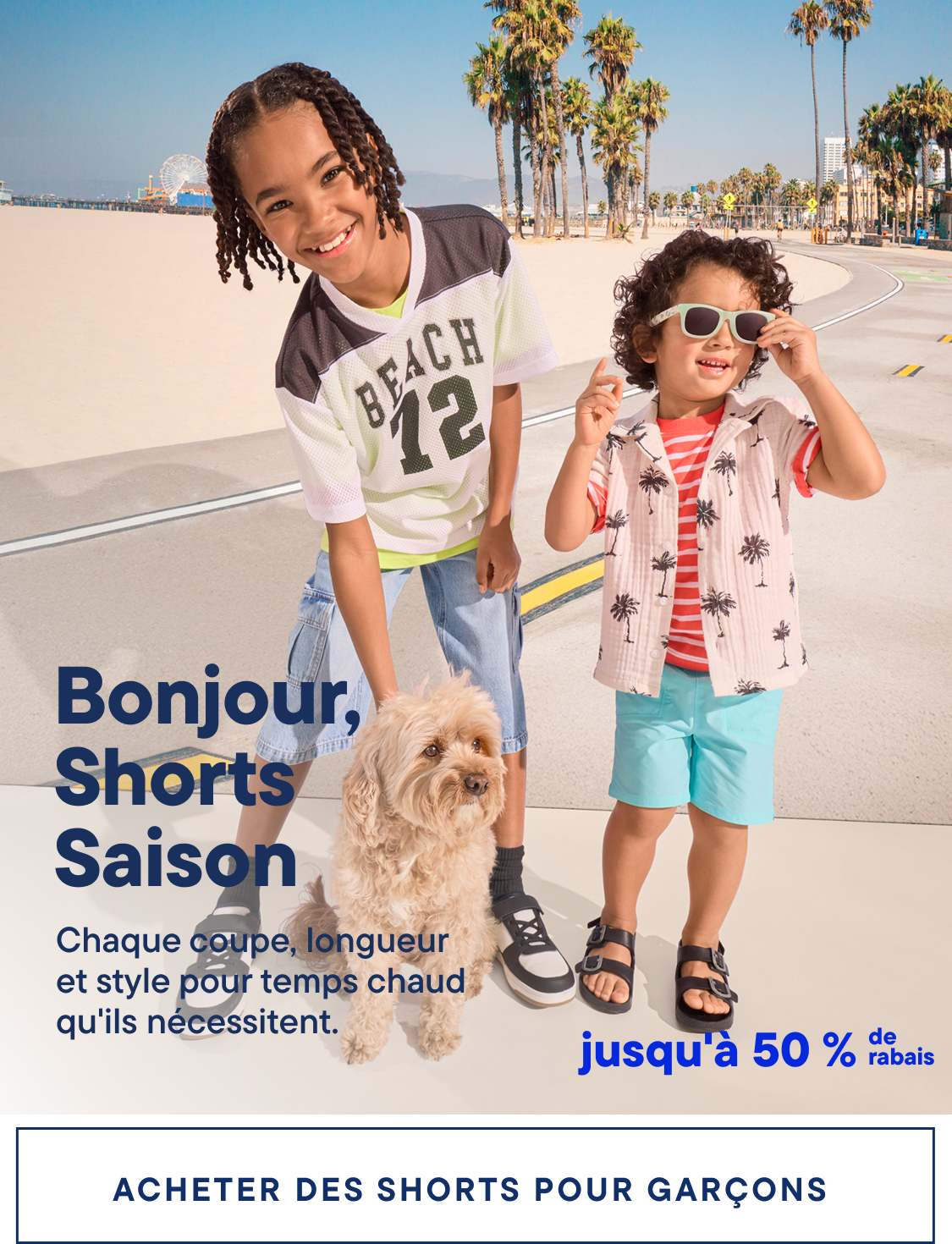 La photo montre deux jeunes enfants, un garçon et une fille, debout sur une plage bordée de palmiers. Le garçon porte un t-shirt « Beach 42 » et la fille un t-shirt à rayures roses et blanches. Tous deux sourient et semblent profiter du beau temps.