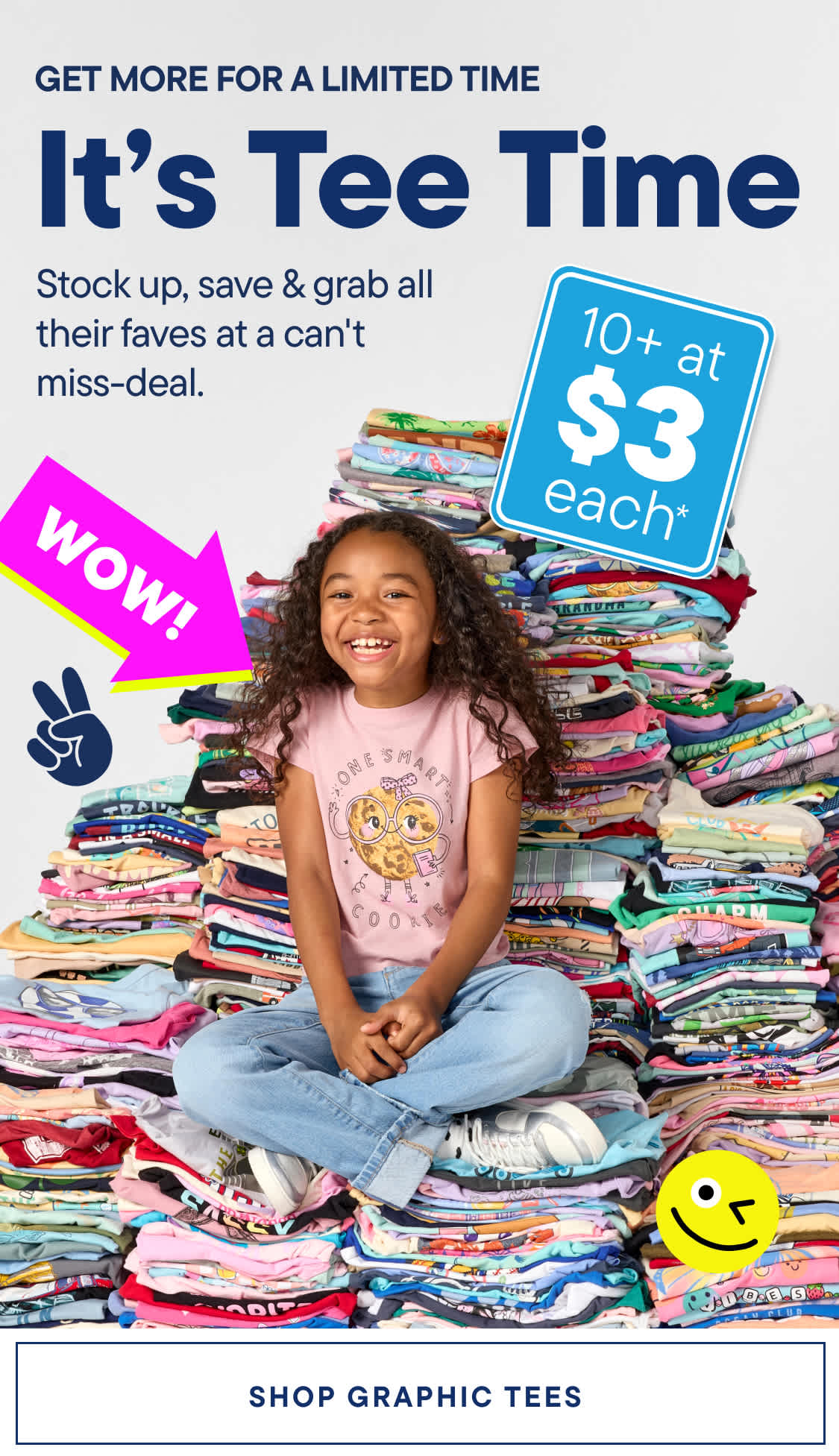 A young girl sits cross-legged on a large pile of colorful t-shirts, with a "WOW!" graphic and a smiley face in the background.