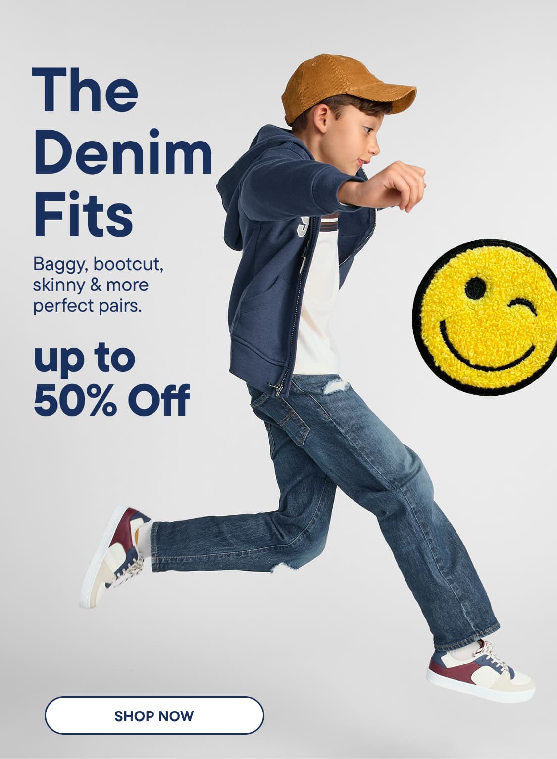 A young boy in denim jeans and a hoodie jumps in the foreground, with a winking smiley face and sale text on a light gray background.