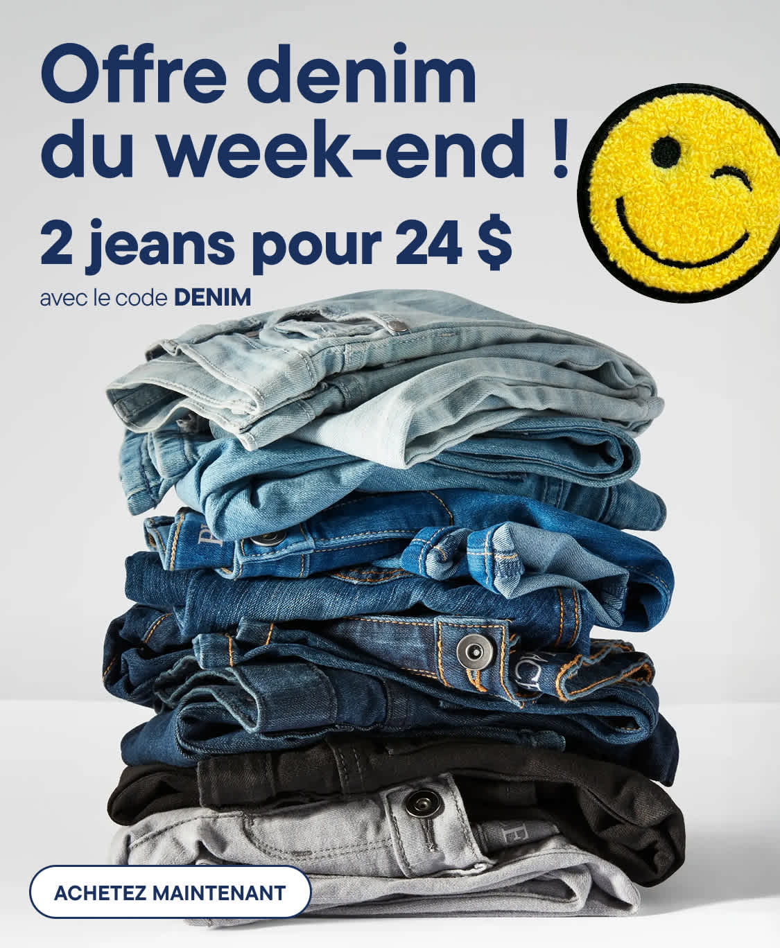 Au premier plan, une haute pile de jeans pliés dans différentes nuances de bleu et de gris occupe tout le volume, tandis qu'à l'arrière-plan figure une publicité pour une offre spéciale denim du week-end ! avec un smiley clin d'œil.