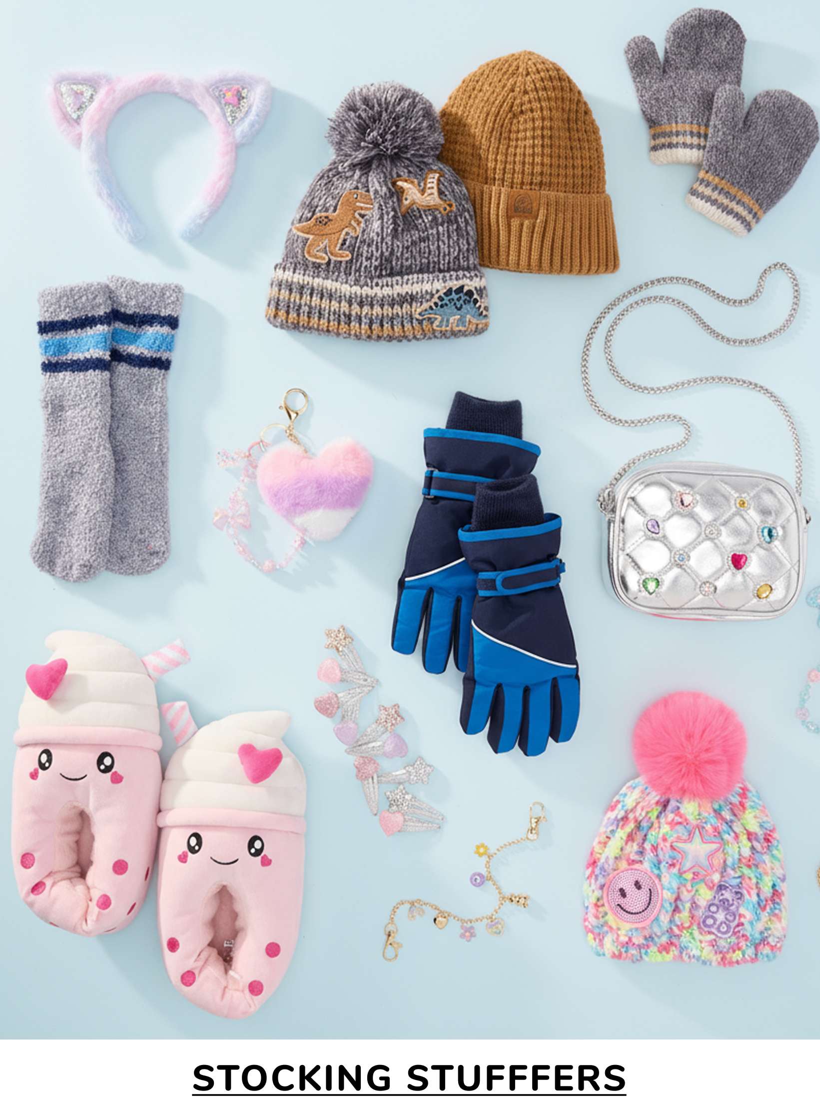 A collection of various winter accessories, including hats, gloves, socks, and other cozy items, arranged on a light blue background.