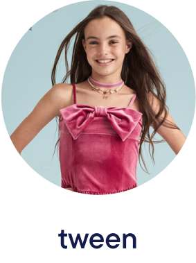 The image shows a young girl with long brown hair wearing a pink satin top with a bow, smiling against a light blue background.