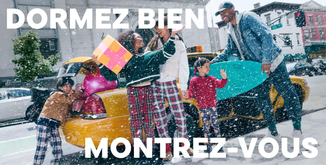 Un groupe de personnes vêtues de vêtements colorés et à motifs se tiennent dans la neige, tenant divers objets et semblant participer à une sorte d'activité festive ou festive.