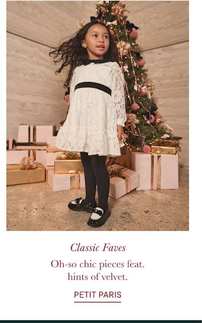 The image shows three young children sitting on stairs in front of a decorated Christmas tree, with the text "For the Trendsetters. Classic meets chic in looks your fashion icon will adore. PETIT PARIS" displayed below.