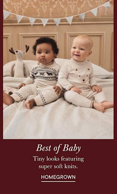 Two young children, a boy and a girl, sitting on a bed surrounded by festive decorations and a cozy, homey atmosphere.