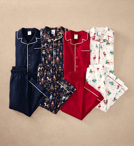A collection of colorful and patterned pajama sets, including navy blue, floral, red, and Christmas-themed designs, neatly arranged on a beige background.