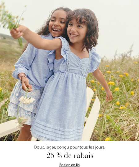 Deux jeunes filles en robes bleues s'enlacent et sourient dans un champ de fleurs.