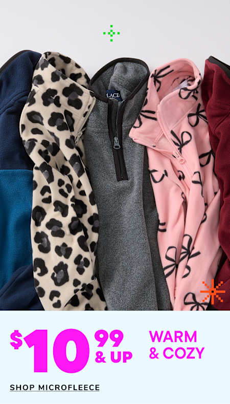 Two young children, a boy and a girl, are wearing matching beige hooded sweatshirts and smiling at each other in a warm and cozy setting.