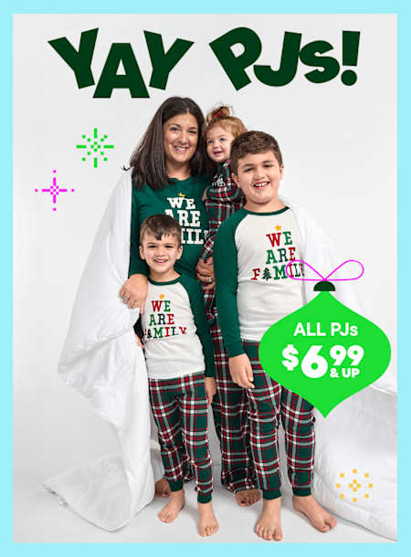 A family of three wearing matching red "Merry Christmas" shirts stands in front of a bright, colorful background with the text "Yay PJs!" and a price promotion for all PJs at $7.99 and up.