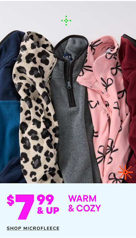 Two young children, a boy and a girl, are wearing matching beige hooded sweatshirts and smiling at each other in a warm and cozy setting.