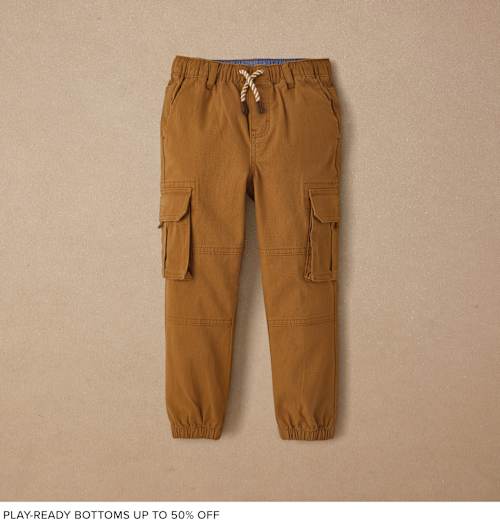 A pair of tan cargo pants with drawstring waist and pockets, against a plain beige background.