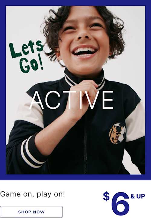 A young child with curly hair is smiling enthusiastically while wearing a black and white sports uniform with the text "Let's Go! ACTIVE" on it, set against a plain blue background.