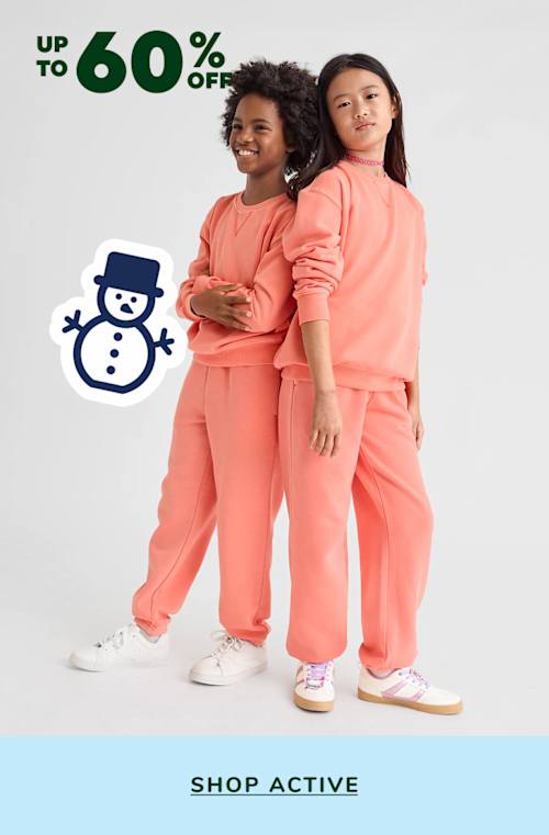 Two young girls wearing matching bright pink outfits stand in front of a white background with a "Up to 60% off" sale sign and a snowman icon.
