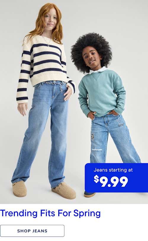 The image features two young individuals, one with long, curly red hair and the other with short, dark hair, both wearing casual denim jeans and colorful sweaters. They are standing in front of a plain background with a sign advertising jeans starting at $9.99.