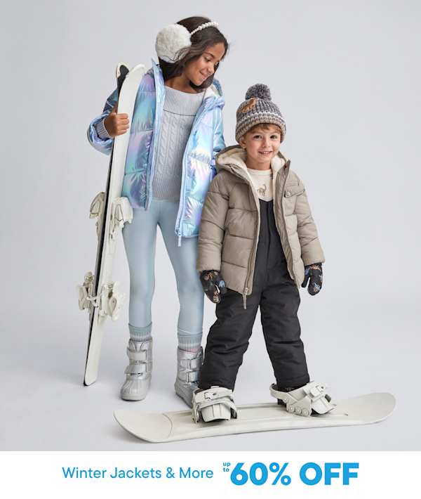 Two young individuals, a girl and a boy, are dressed in warm winter attire and holding ski equipment, standing against a plain white background.