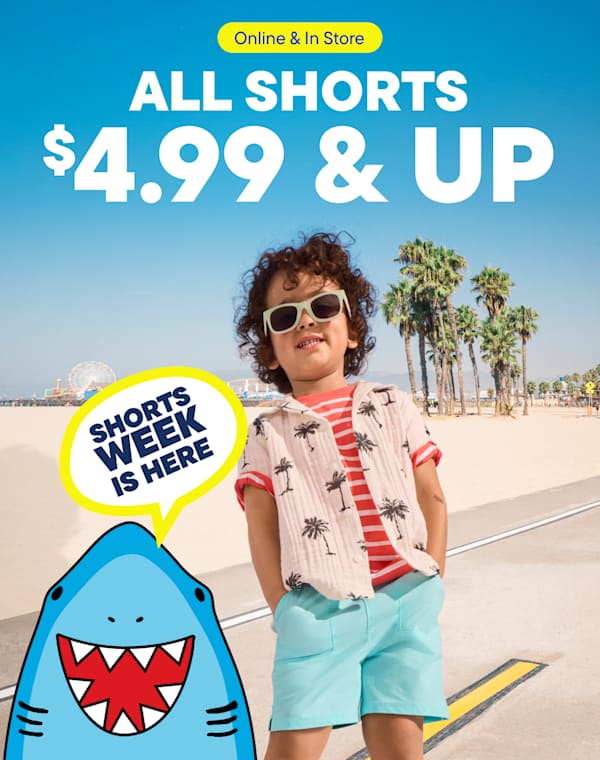 A young person wearing sunglasses and a patterned shirt stands on a beach with palm trees in the background, promoting a sale on shorts.