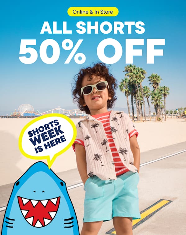 A young person wearing sunglasses and a patterned shirt stands on a beach with palm trees in the background, promoting a sale on shorts.