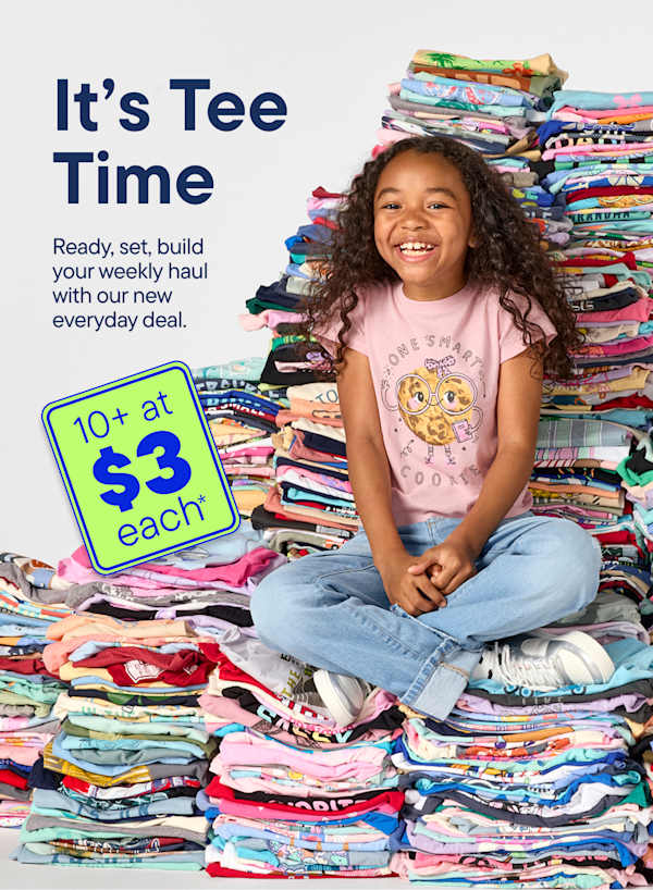 A smiling young girl sits cross-legged in front of a massive pile of colorful t-shirts, with a promotional graphic advertising 10+ at $3 each to her left.