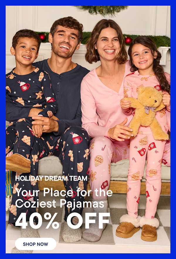 A smiling family in matching pajamas sits on a bench in the foreground, with a decorated Christmas tree and a cozy living room in the background.