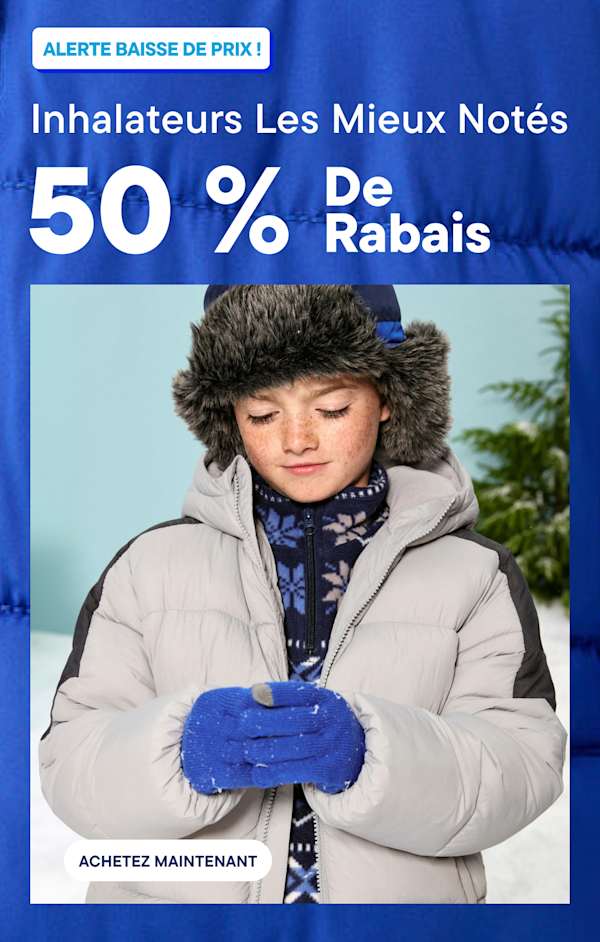 A child wearing a grey puffer jacket, blue gloves, and a faux-fur hat stands against a snowy background with a pine tree | All Outerwear50% Off