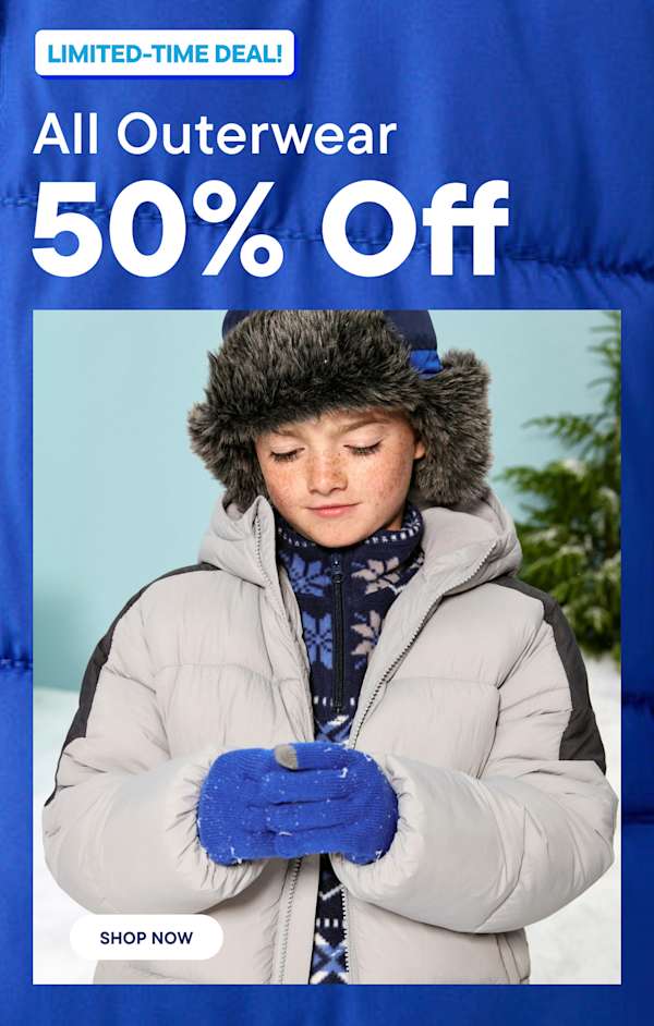 Un niño con una chaqueta acolchada gris, guantes azules y un gorro de piel sintética aparece en primer plano sobre un fondo invernal nevado | Toda la ropa de abrigo con un 50 % de descuento