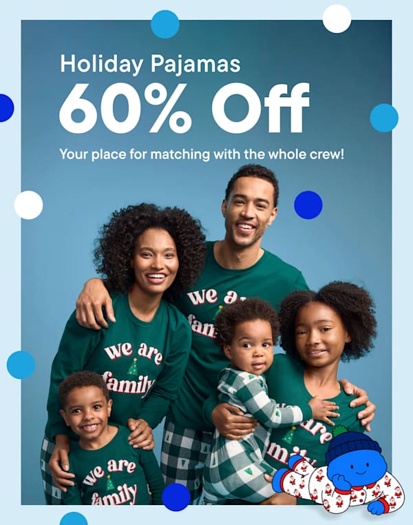 A smiling family in matching green holiday pajamas stands against a blue background, accompanied by a promotional offer for 60% off holiday pajamas and a cute blue character in the foreground | Holiday Pajamas 60% Off